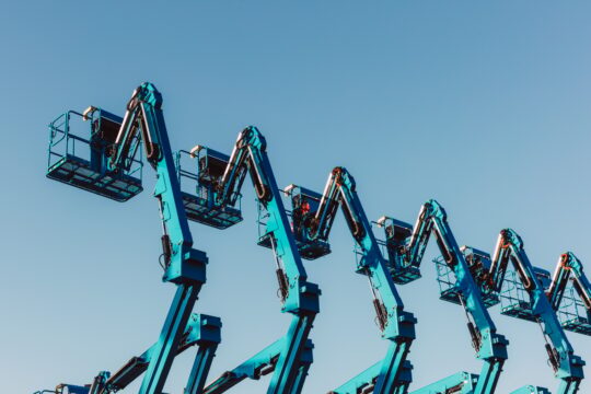 Row of hydraulic mobile cherry picker platforms at outdoor storage facility